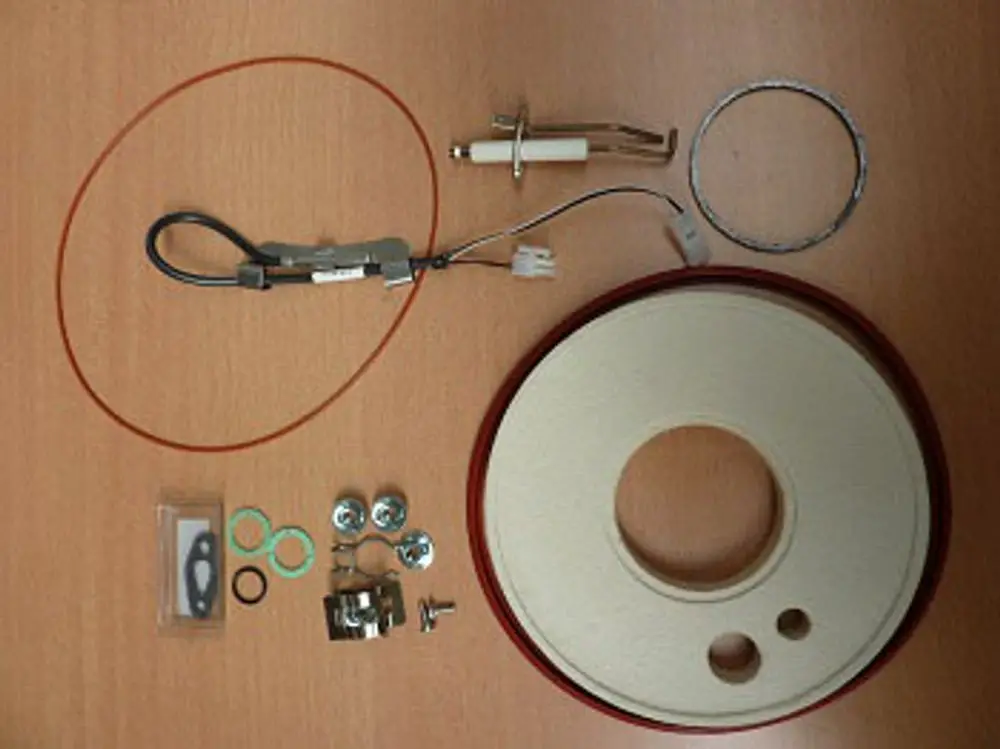 Wartungssatz für Remeha, bestehend aus verschiedenen Bauteilen: Kabel, Dichtungen, Schrauben, ein Gasket, und ein runder Gehäusedeckel.